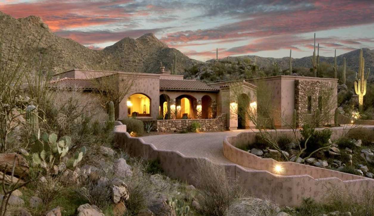 A Tucson custom home at dusk with mountains in the background