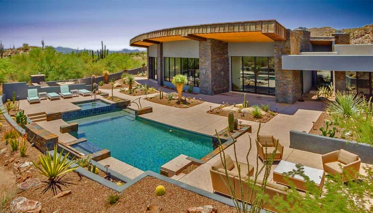 Aerial view of a beautiful swimming pool and hot tub in the backyard of a Stone Canyon house