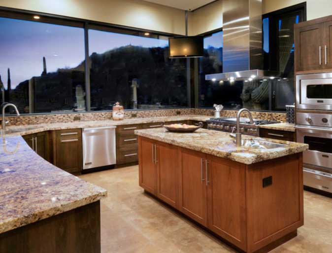 A lovely kitchen with large clear glass windows looking out on the desert view