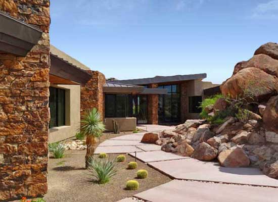 Large landscaping rocks creating a walkway to a Tucson custom home