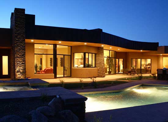 The backyard of a goregeous contemporary house with a large swimming pool and hot tub